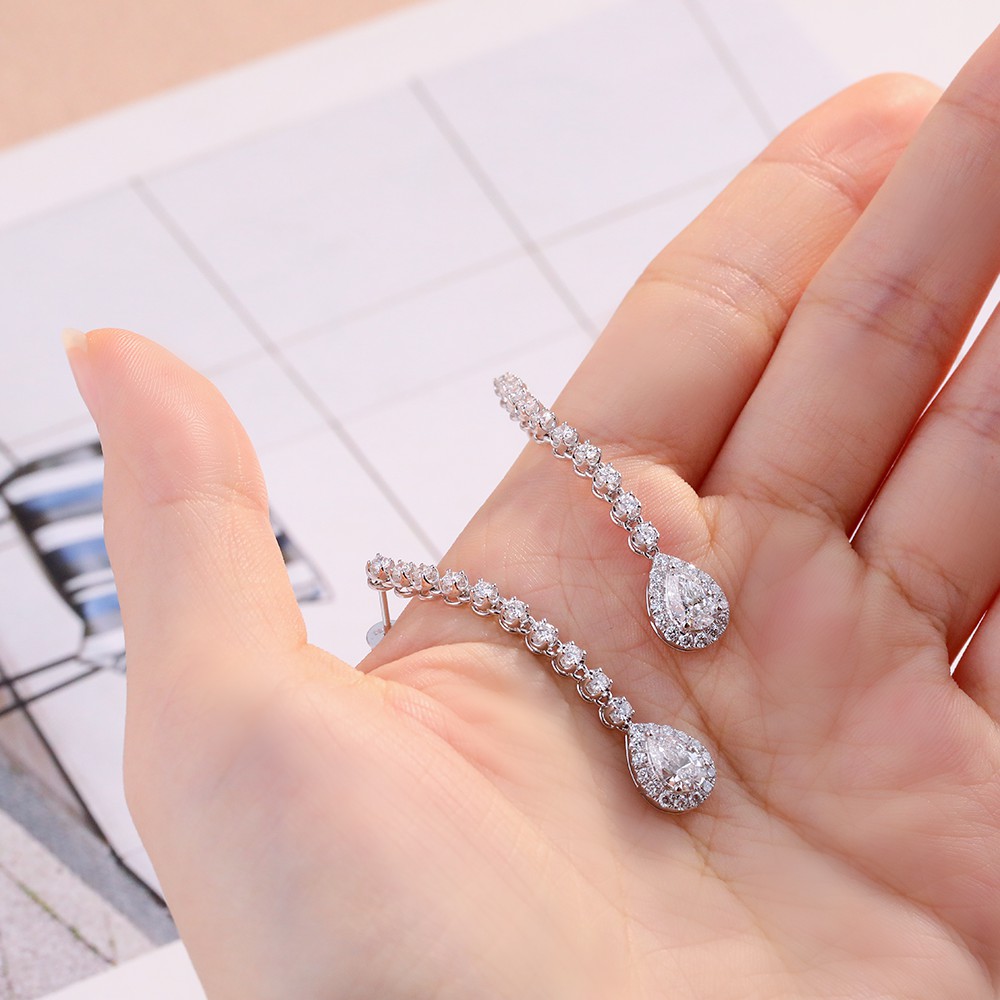 Pendientes de diamantes con diseño envolvente en oro de 18 quilates y forma de pera de 1 quilate.