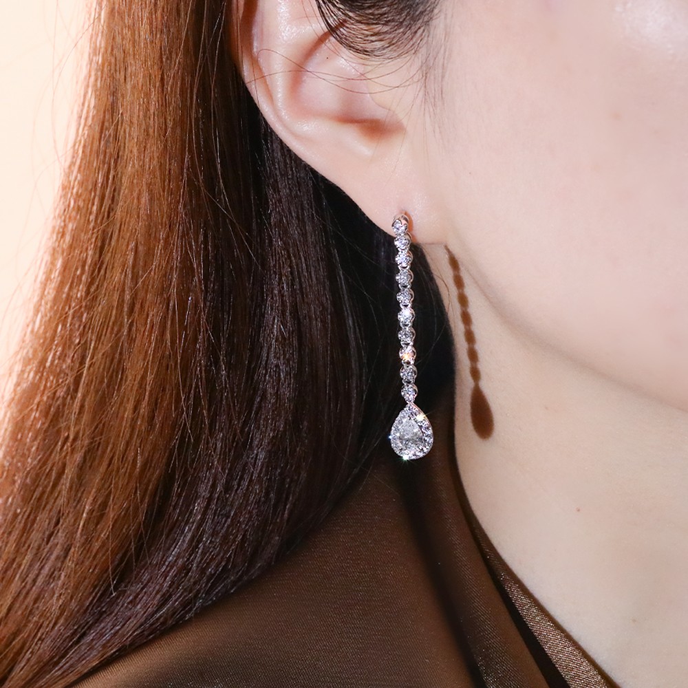 Pendientes de diamantes con diseño envolvente en oro de 18 quilates y forma de pera de 1 quilate.