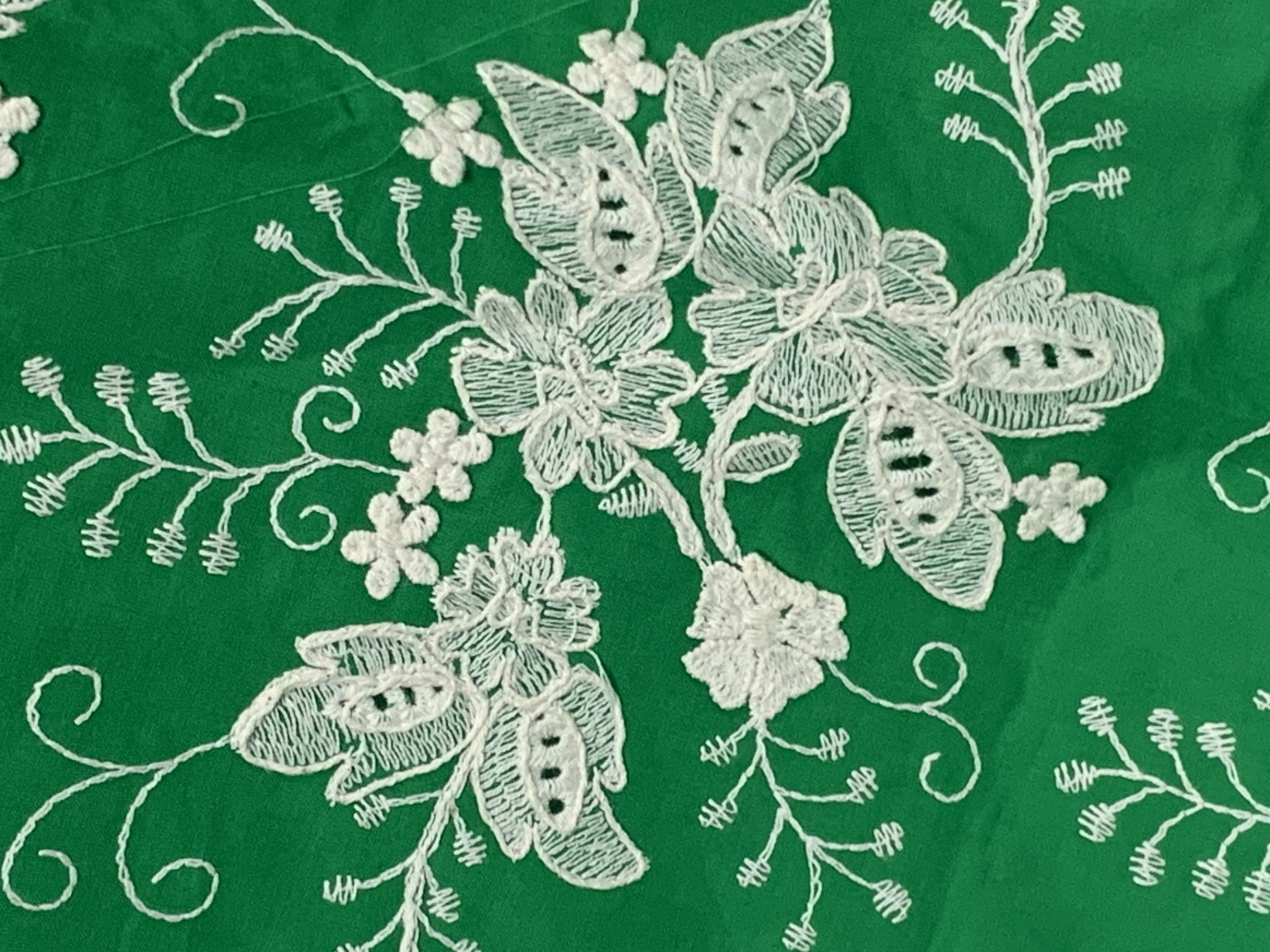 Green cotton fabric with floral embroidery and ribbon details. Used for clothing, home textiles, decorations, skirts, and headwear.